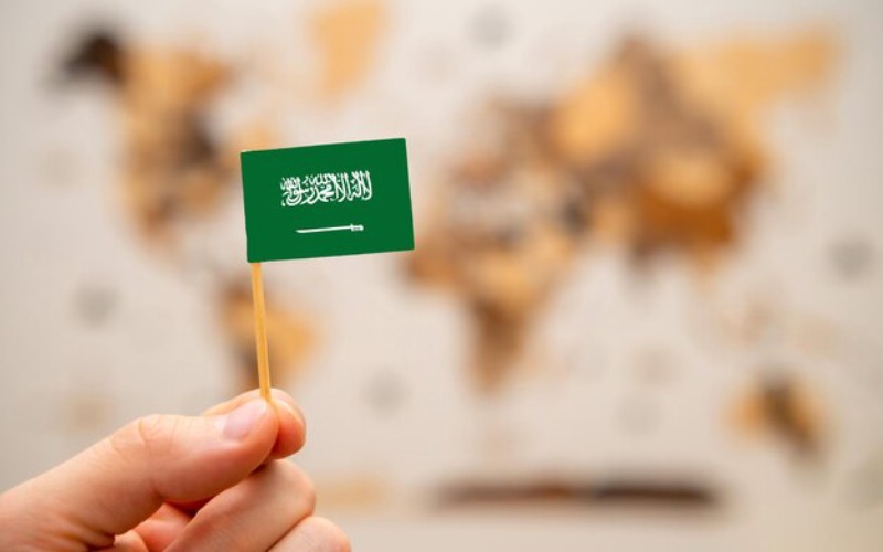 saudi arabia flag mans hand wooden world map background global economy geopoliticscon