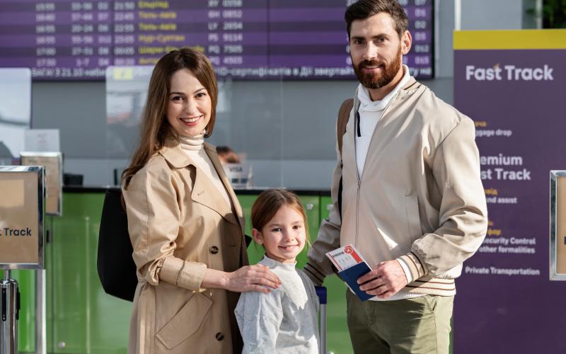 Smiling family at airport with passports and luggage