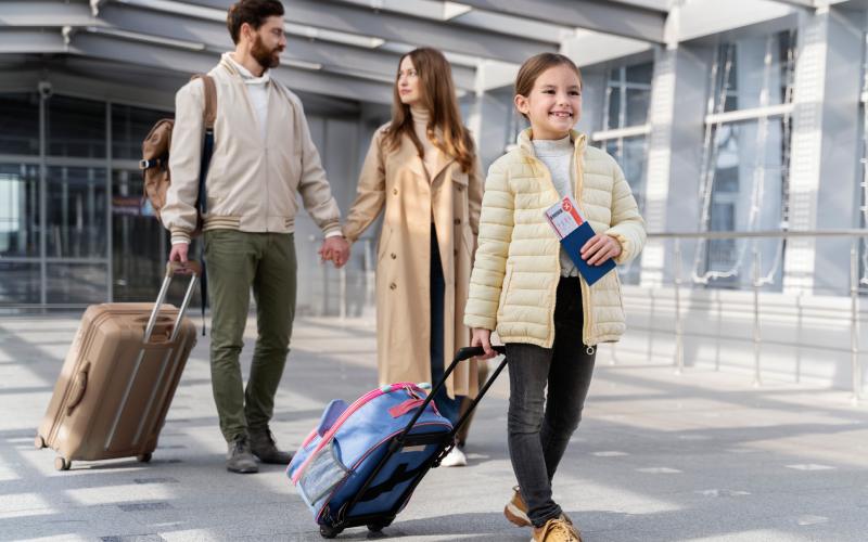Family with child walking through airport with luggage