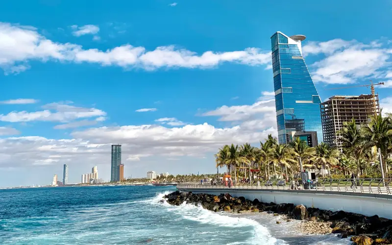 Modern seafront skyline of Jeddah, Saudi Arabia with palm trees and blue sky