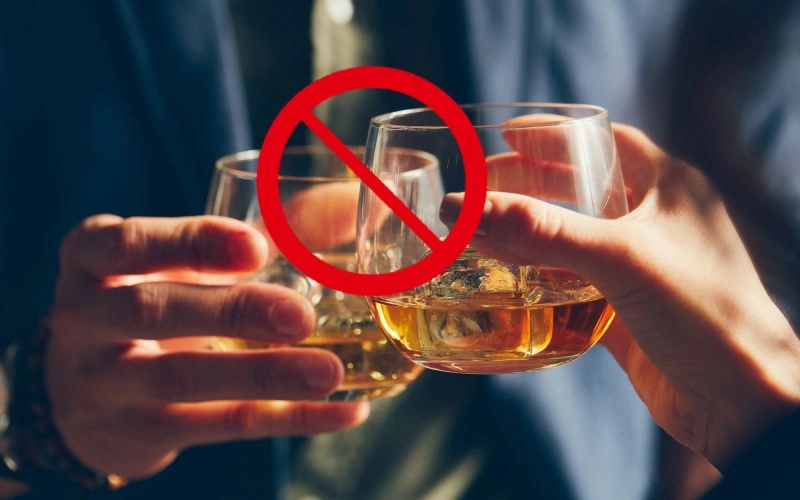 Two people holding whiskey glasses with a no-alcohol symbol overlayed