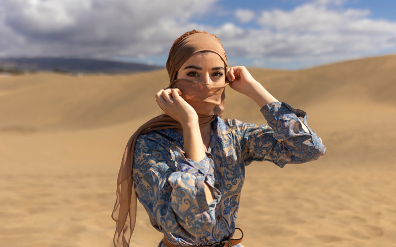 Medium shot woman in desert with scarf